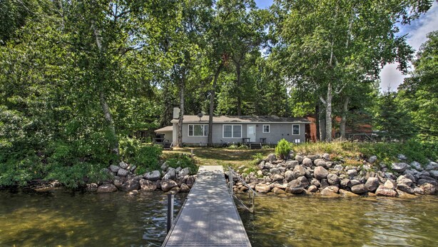 A house with a dock leading to a river, surrounded by trees and rocks. - Pine River Lake Home w/ Boat & Kayak Rentals! (Pine River)