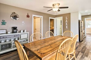 A dining area with a wooden table and chairs, a ceiling fan, and a wall with coffee-themed decorations. - Pine River Lake Home w/ Boat & Kayak Rentals! (Pine River)
