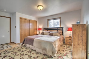 A bedroom with a bed, two bedside lamps, a window, a wooden wardrobe, and a door. - Pet-friendly Malta Home Near Hunting Areas! (Malta)