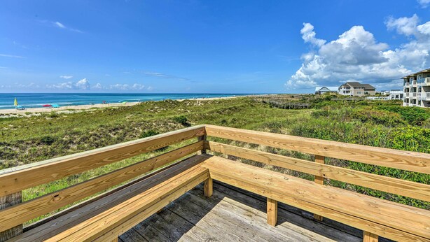 A wooden deck overlooking a beach with a clear sky. - Point Emerald Resort Retreat: Walk to Beach! (Emerald Isle)
