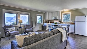 A compact living space with a sofa, chairs, a dining table, and a kitchen area with a refrigerator, microwave, and cabinets. - Scenic Studio w/ Loft & View of the Columbia River (Carson)