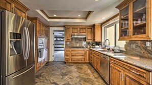 A modern kitchen with wooden cabinets, stainless steel appliances, and a granite countertop. - Spacious El Cajon Villa - 14 Mi to Downtown! (El Cajon)