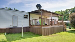 Una casa móvil con terraza cercada y antena parabólica.