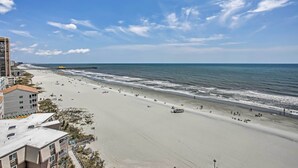 A beach with a promenade, buildings, and a pier. - Steps to Shore: Beachfront Studio w/ Pool Access! (Myrtle Beach)