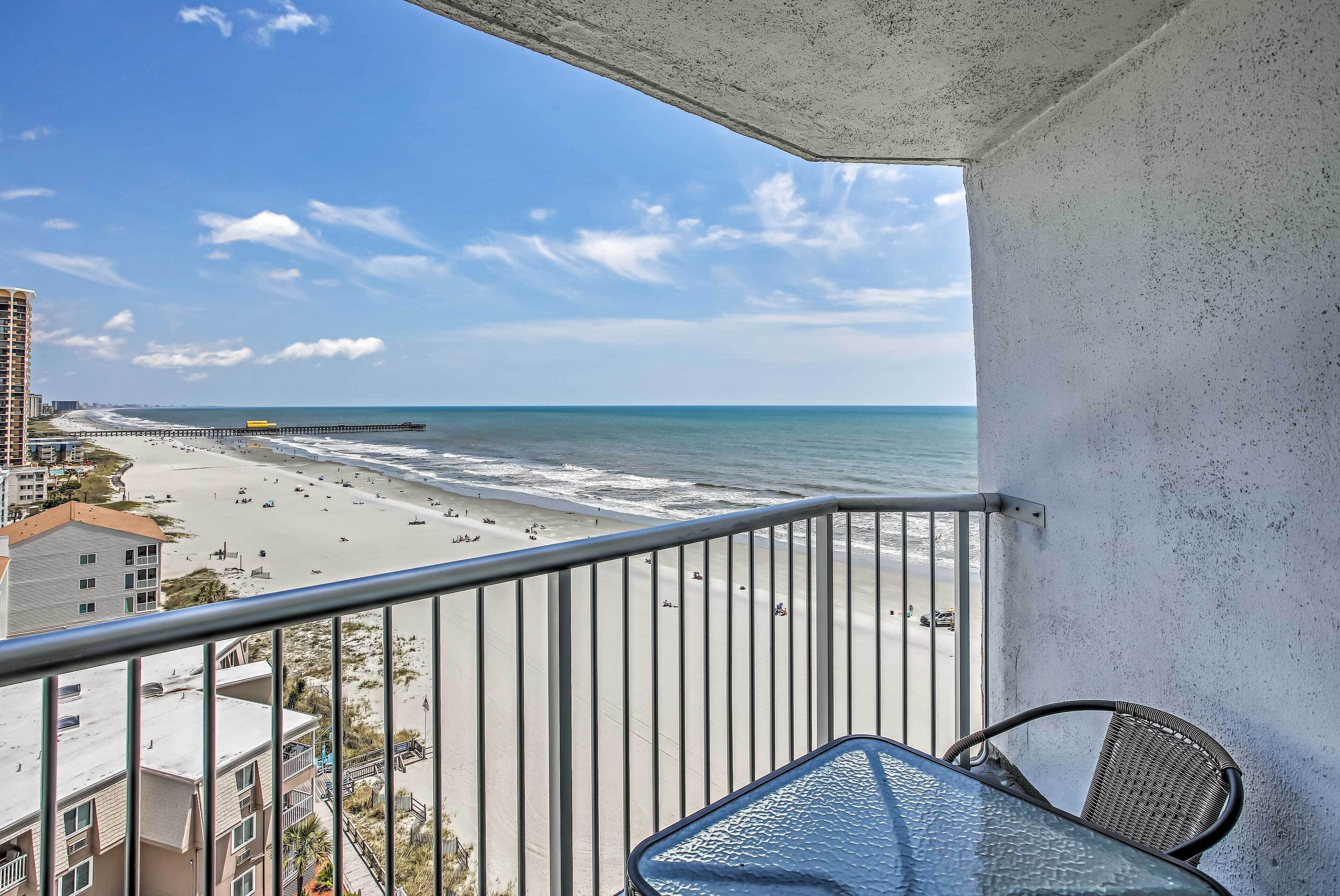 A balcony with a view of a beach and ocean.