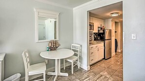 A compact kitchen with white cabinets, a microwave, and a refrigerator. - Steps to Shore: Beachfront Studio w/ Pool Access! (Myrtle Beach)