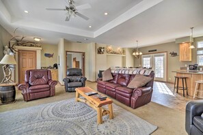 A spacious living room with leather sofas, a wooden coffee table, and a patterned rug. - Charming Cody Vacation Home w/ Mtn Views! (Cody)