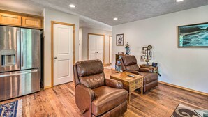 A living room with leather recliners, a coffee table, and a kitchen with stainless steel appliances. - Hammond Home 2 Blocks to Marina & Columbia River! (Hammond)