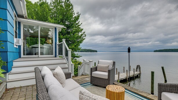 A waterfront patio with outdoor seating, a view of the water, and a dock. - Winnipesaukee Lakefront Home With Dock & Views! (Alton Bay)