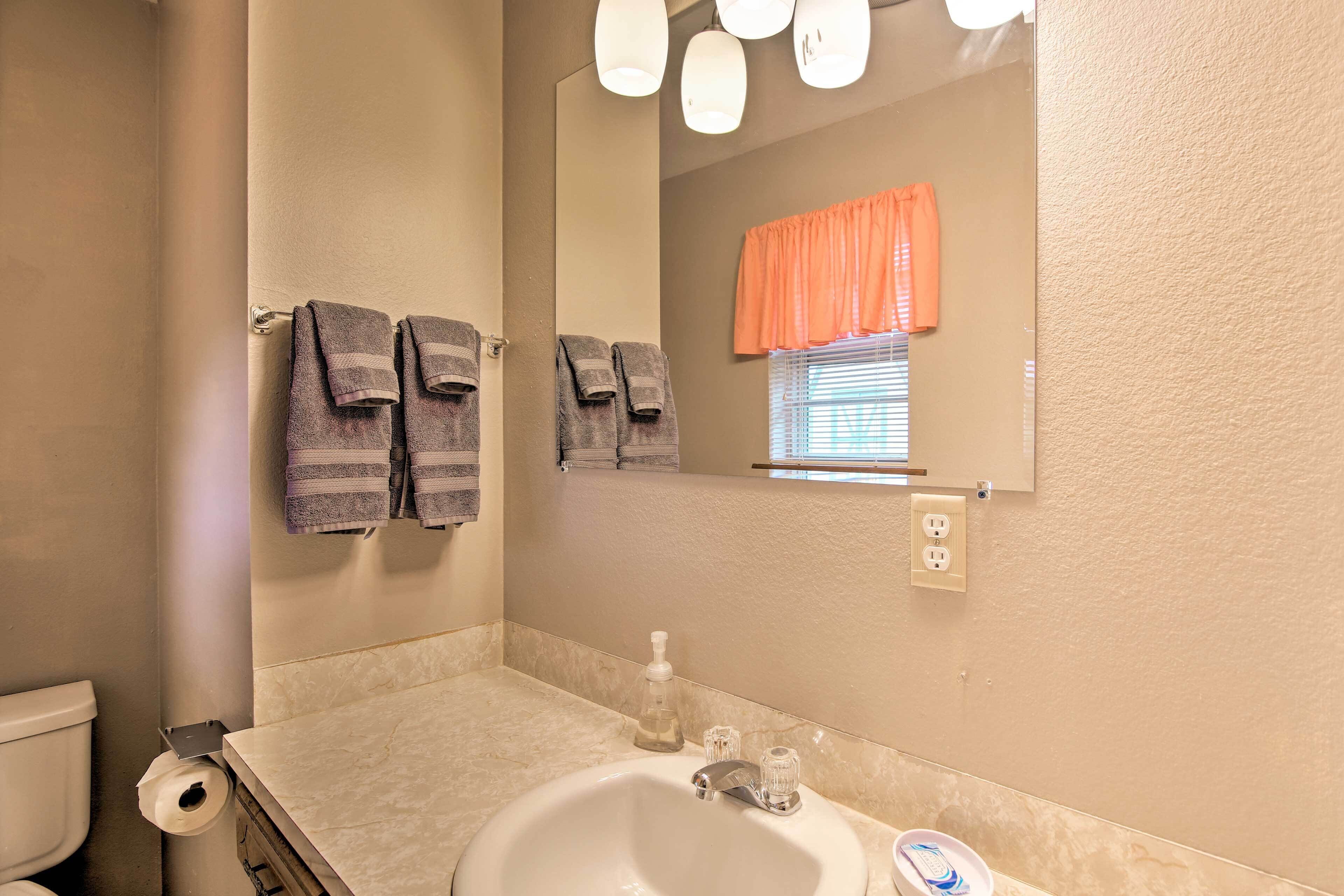 Une salle de bain équipée d’un lavabo, d’un miroir, d’un porte-serviettes et de toilettes.
