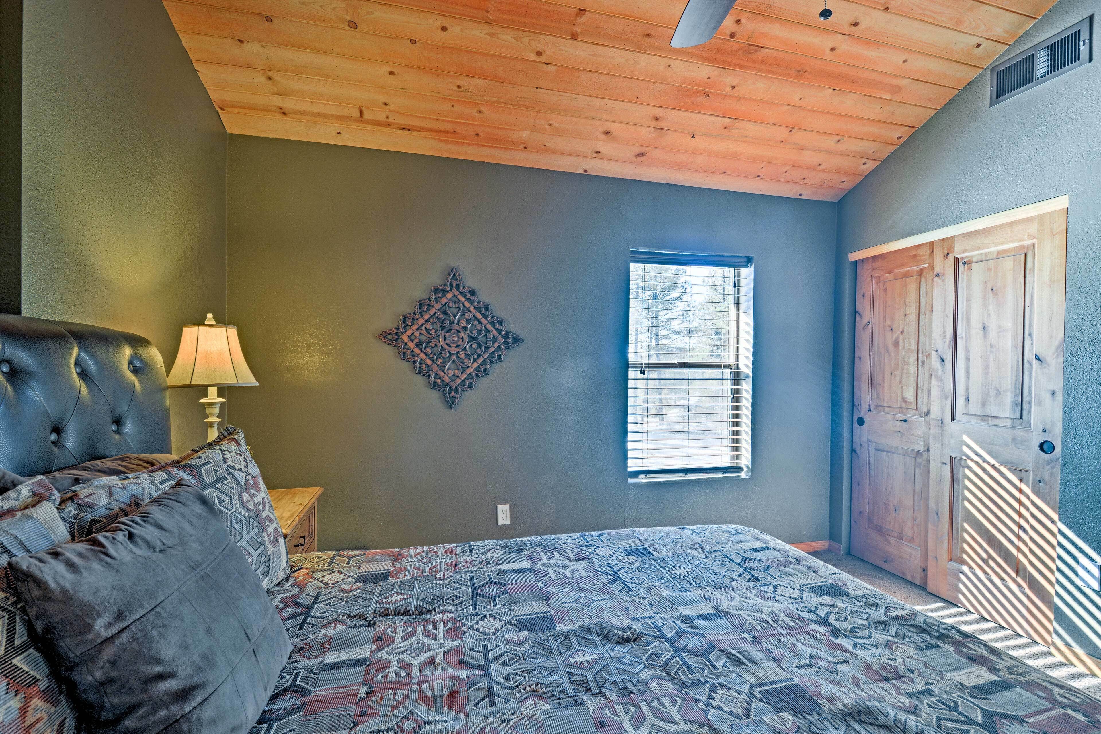 Un dormitorio con cama, mesita de noche, lámpara, ventana y puerta.