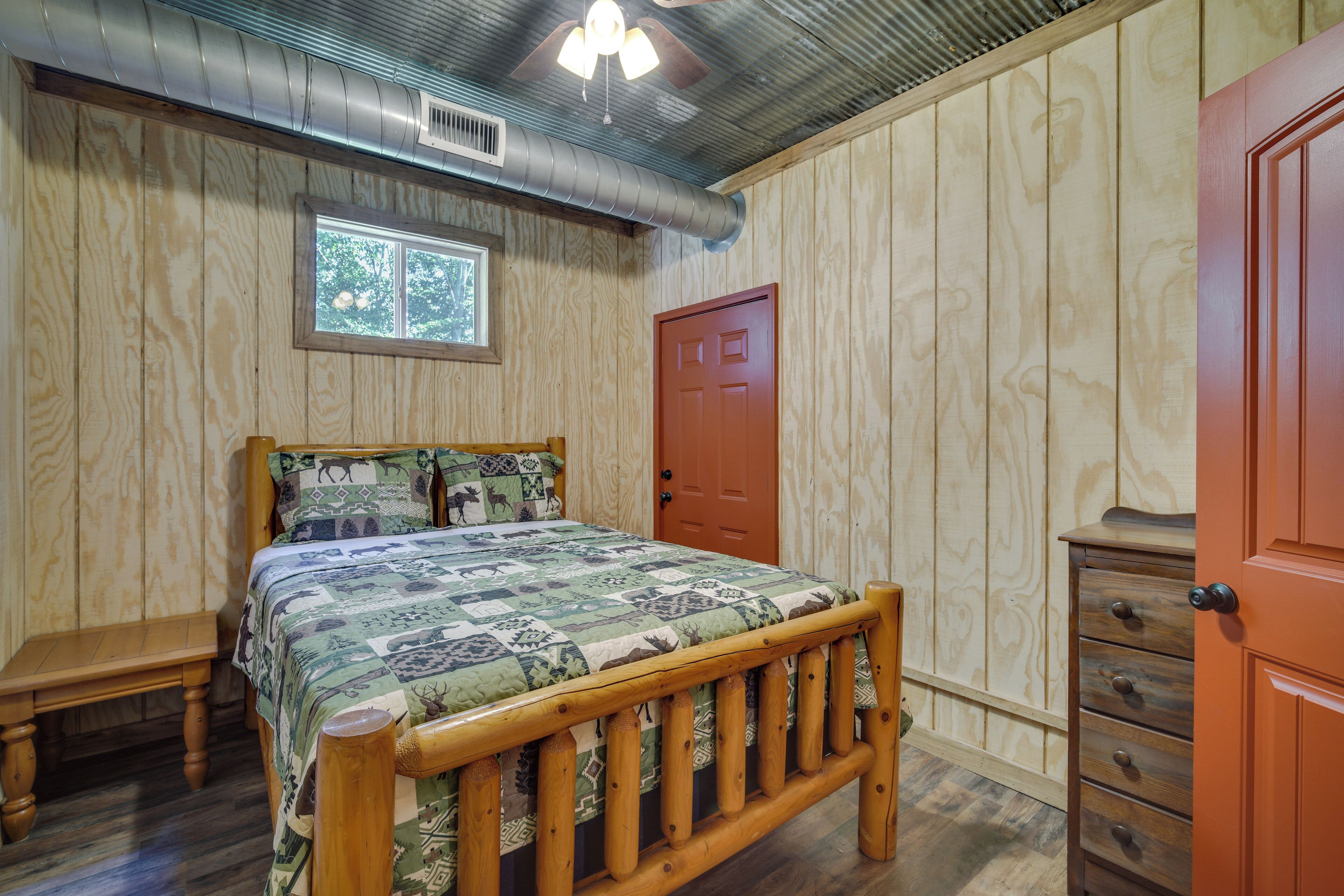 A bedroom with a wooden bed, a window, a door, and a dresser.