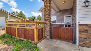 A residential property with a wooden fence, a stone pillar, a gated entrance, and a house with siding and a chimney. - Private Patio + Gazebo: Show Low Hideaway! (Show Low)