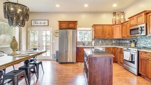 A kitchen with wooden cabinets, stainless steel appliances, a chandelier, and a dining area with a table and chairs. - Private Patio + Gazebo: Show Low Hideaway! (Show Low)
