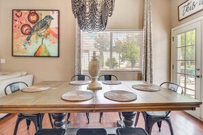 A dining room with a wooden table, black chairs, a decorative centerpiece, and a large painting on the wall. - Private Patio + Gazebo: Show Low Hideaway! (Show Low)