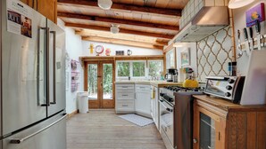 A kitchen with wooden cabinets, a stainless steel refrigerator, a stove, and a microwave.