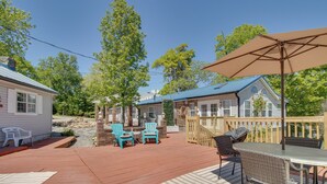 Une terrasse dotée de mobilier d’extérieur, comprenant des chaises et une table, ainsi qu’un grand parasol.