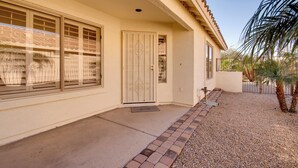 A house with a front door, large windows, and a small front yard with a palm tree. - 55+ Gilbert Home w/ Yard, Golf Course On-site (Gilbert)