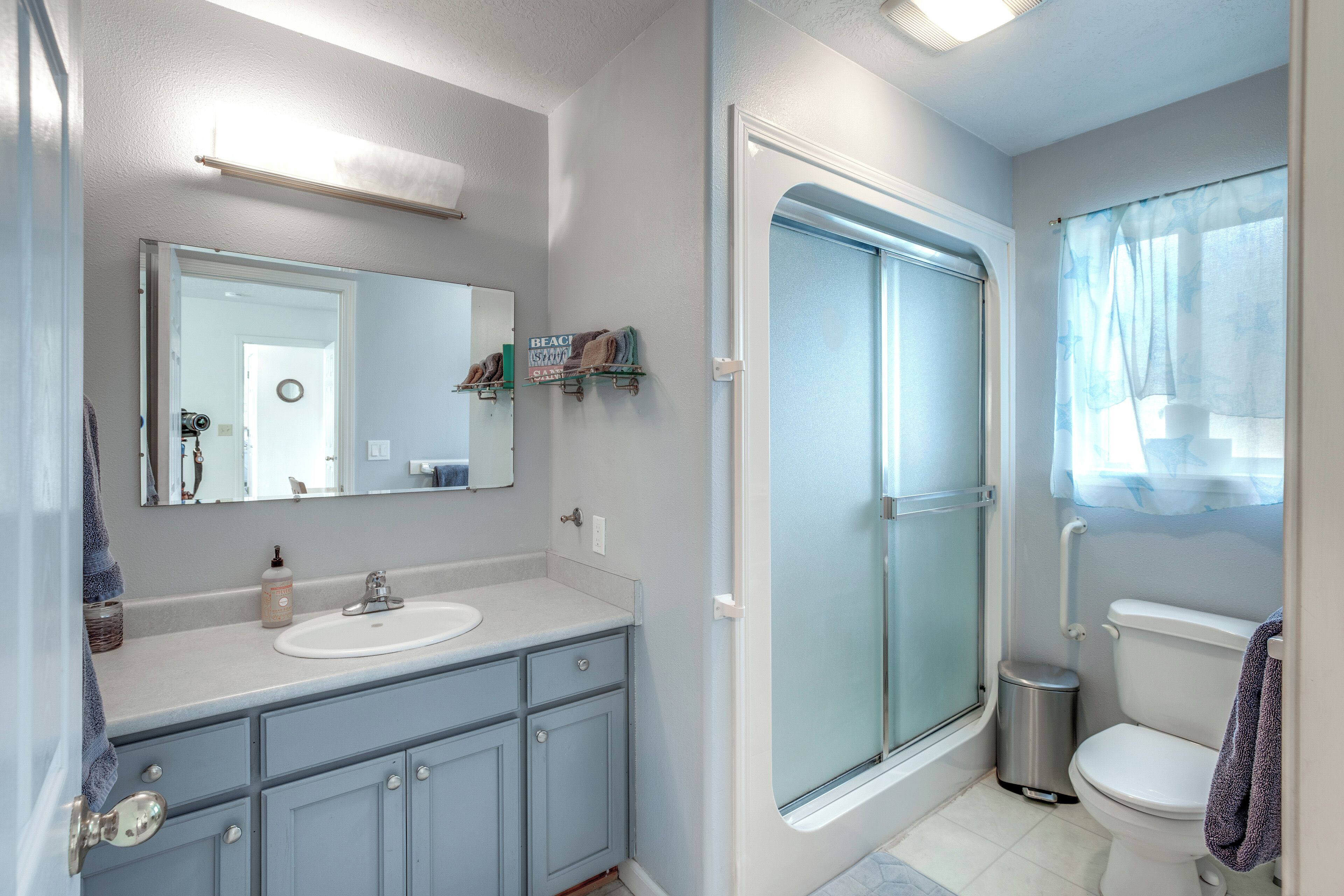 Un baño con lavabo, espejo e inodoro.
