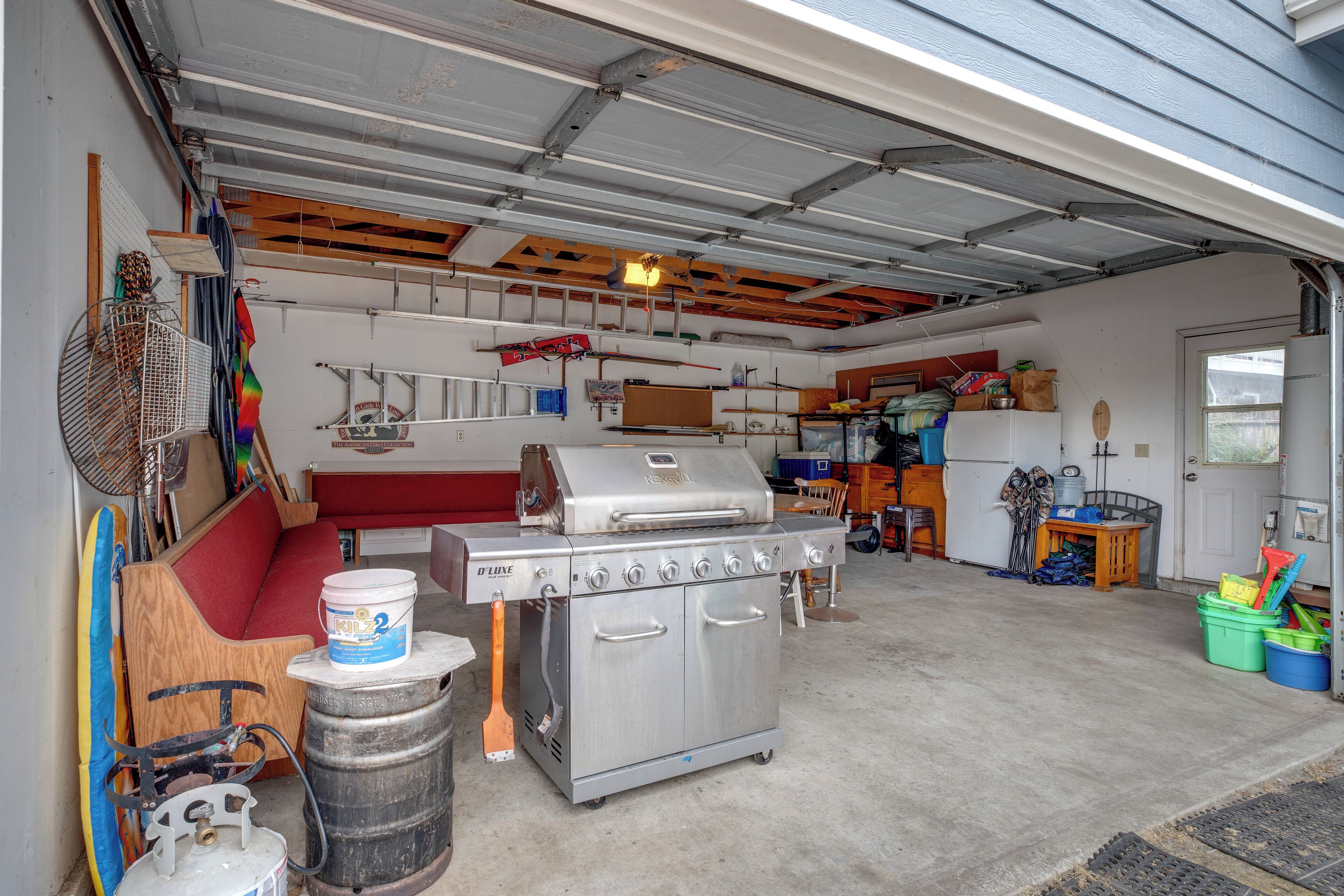 Eine Garage mit einem großen Edelstahlherd, einer Holzbank und verschiedenen Werkzeugen und Geräten.
