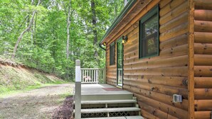Eine Holzhütte mit Veranda und Stufen zum Eingang.