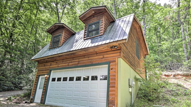 Eine Hütte mit Garage, umgeben von Wald.