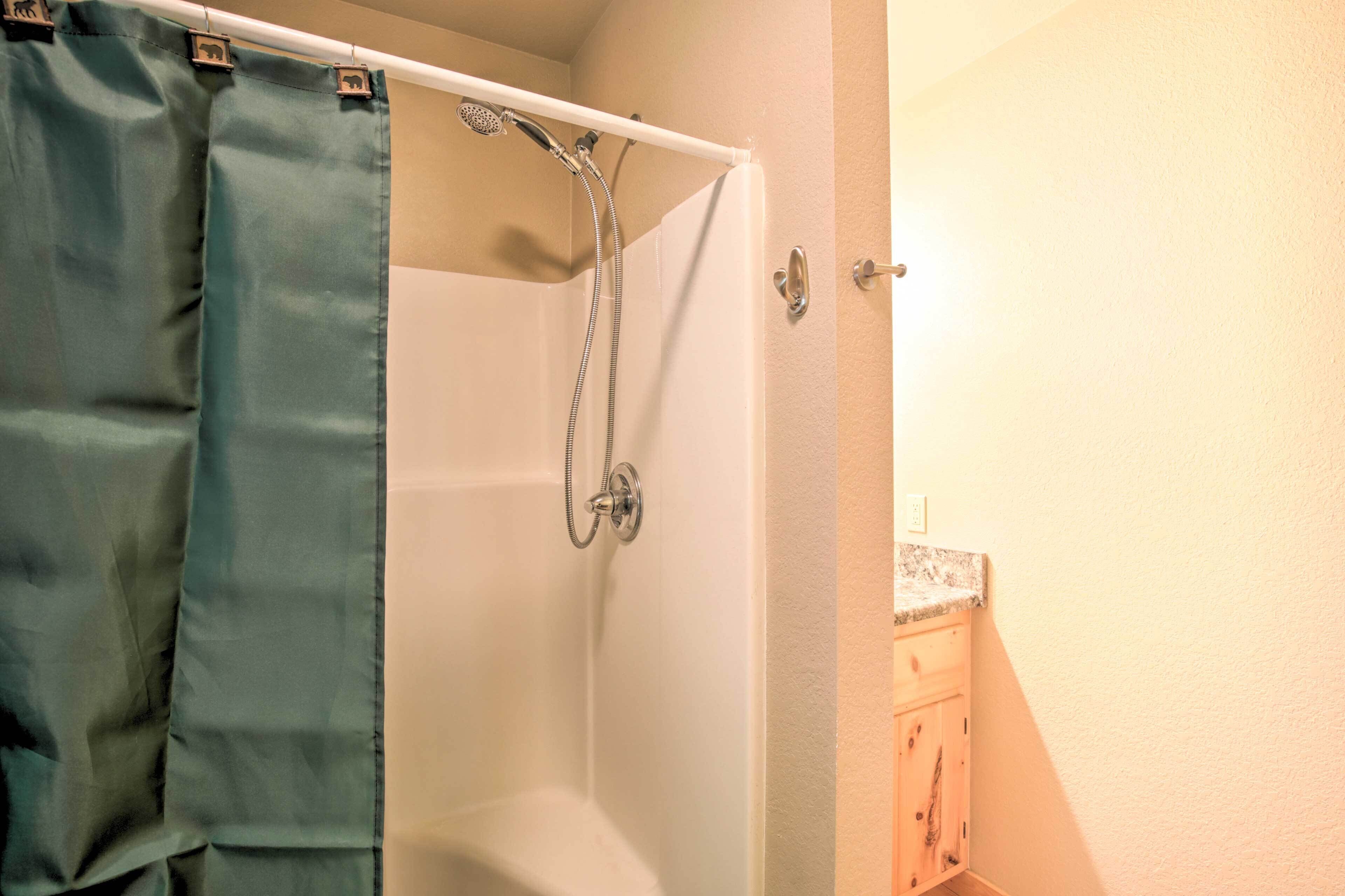 Een badkamer met een douche, een handdoekhouder en een kast.