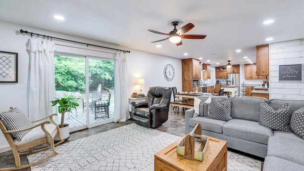 A spacious living room with a sofa, a wooden coffee table, and a dining area with a table and chairs. - Views! Lake Home w/ 2 Decks, Boat Parking & Peace (Garfield)
