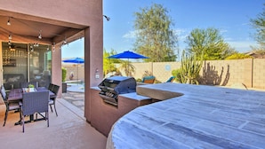 An outdoor patio with a grill, dining table, and chairs. - Fire Pit, Covered Patio: Stylish Goodyear Refuge (Goodyear)