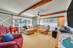 A living room with a sectional sofa, a coffee table, and a television.