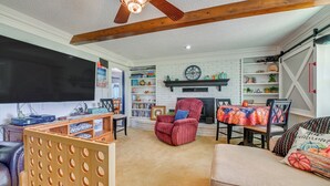 Een gezellige woonkamer met een open haard, boekenkasten en een televisie.