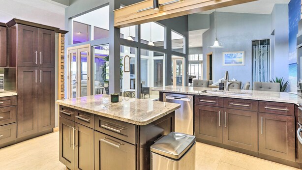 A modern kitchen with dark wood cabinets, granite countertops, and stainless steel appliances. - Huge Home w/ Pool Table Near St Pete Beach! (Seminole)