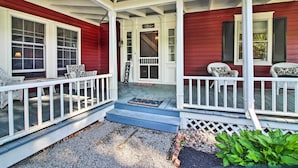 A red house with a porch, white railings, and two wicker chairs. - Vintage Schroon Lake Farmhouse w/ Private Beach! (Schroon Lake)
