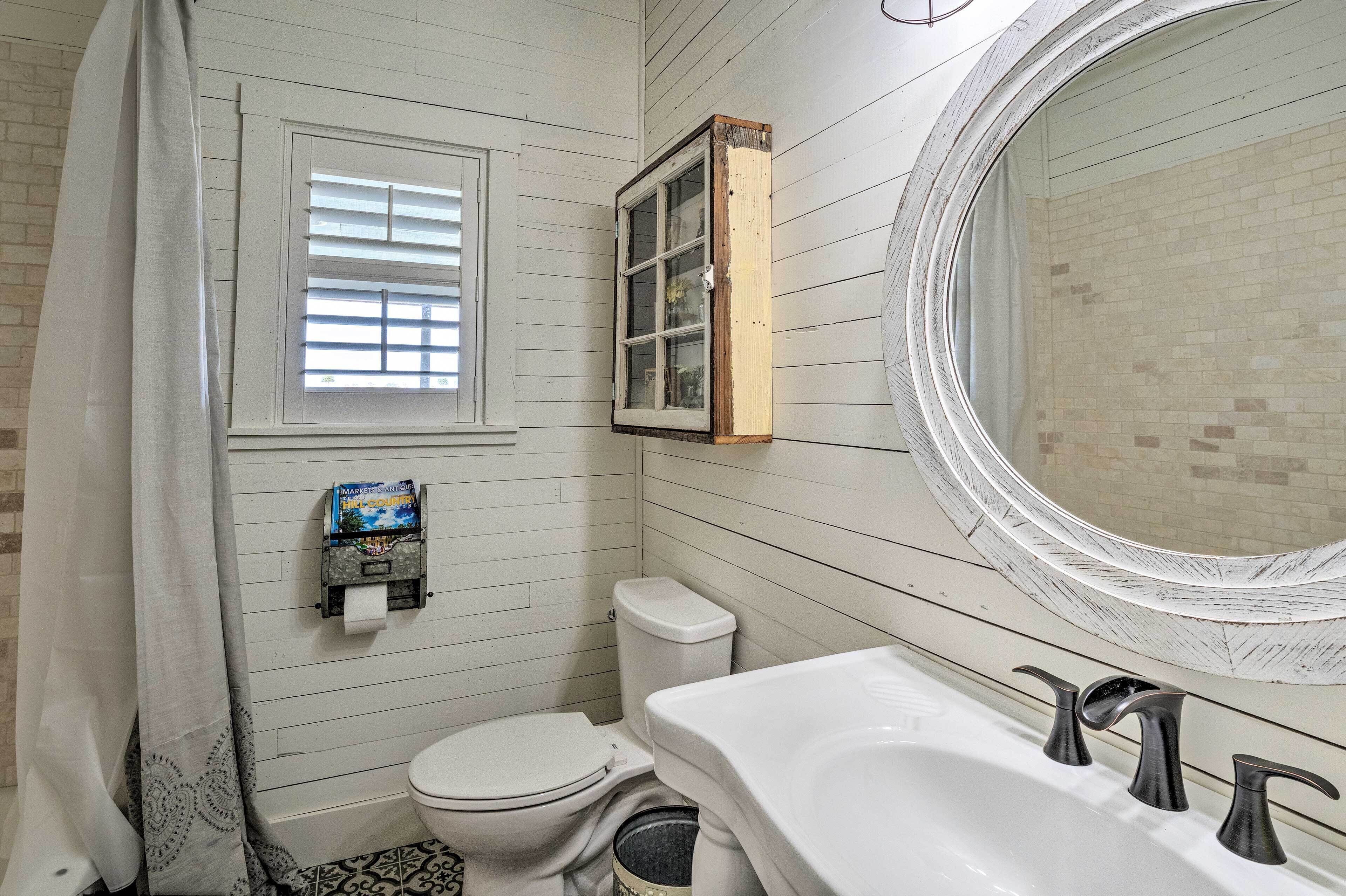 A bathroom with a toilet, sink, and window with blinds.