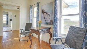 A room with hardwood flooring, a dining table with chairs, a painting on the wall, and a view of the outdoors through a window. - Historic Hoopersville Getaway on Chesapeake Bay! (Fishing Creek)