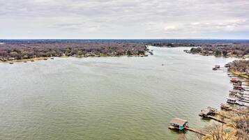 A river with boats docked along the shore, surrounded by trees and buildings.
