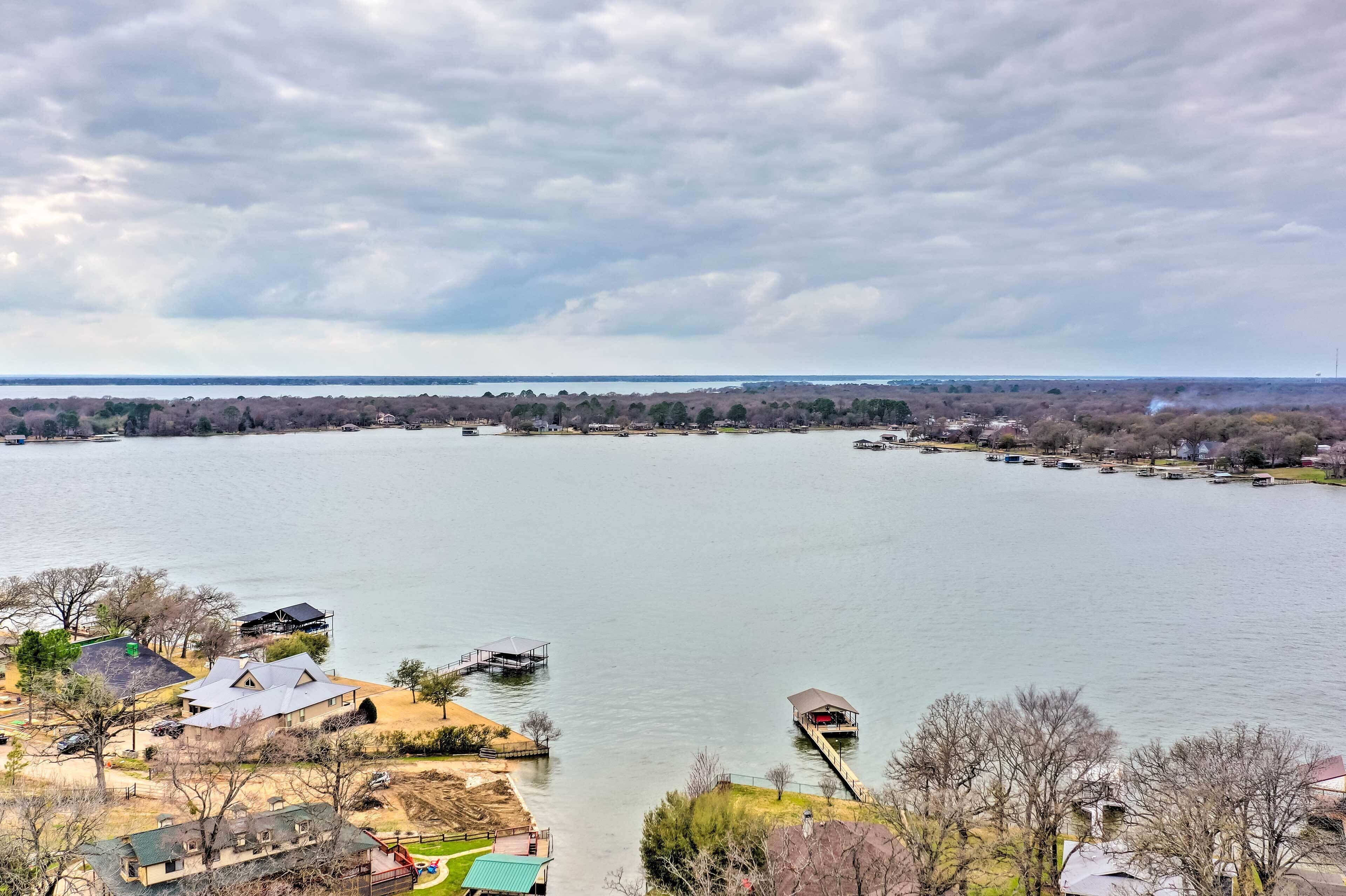 A lakeside property with a dock, a small building, and a boat.