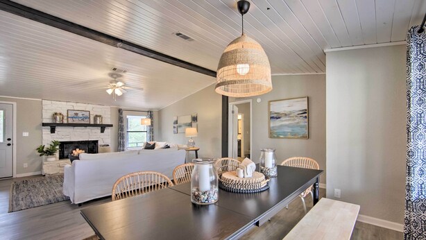 A modern dining area with a long table, wicker chairs, and decorative jars. - Lake View & Decks: Pet-friendly Mabank Home (Mabank)