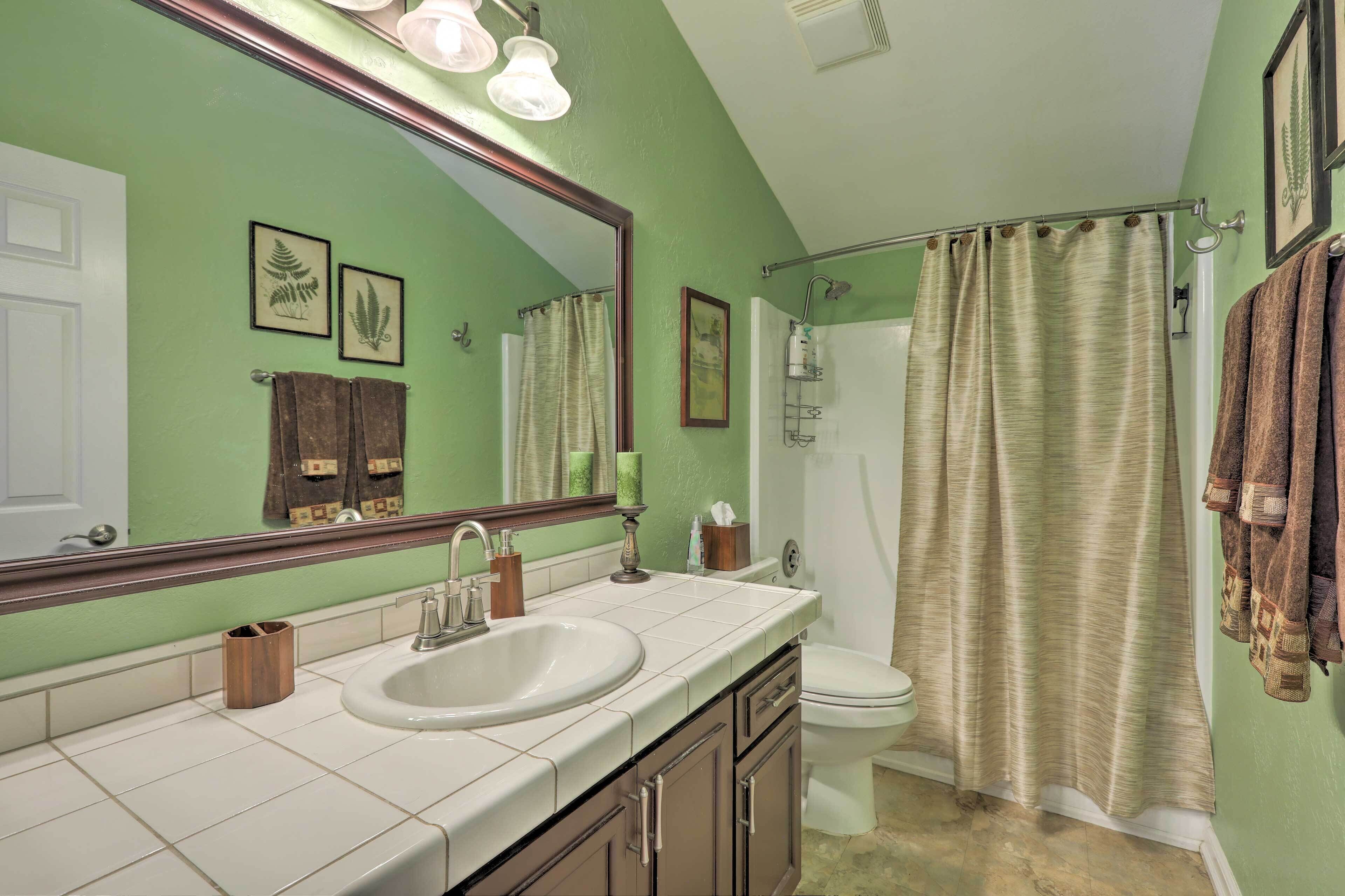 A bathroom with a sink, toilet, and shower curtain.