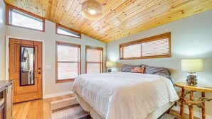 A bedroom with a large bed, wooden ceiling, and multiple windows with blinds. - Strawberry Hideaway in the Pines w/ Hot Tub! (Pine)