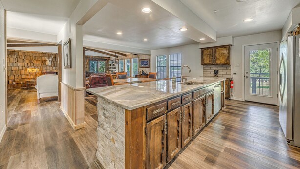 A spacious kitchen with a large island, wooden cabinets, and a stone accent wall. - Ruidoso Home w/ Hot Tub & Sierra Blanca Views (Ruidoso)