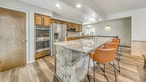 A modern kitchen with a large island, stainless steel appliances, and wooden cabinets. - Ruidoso Home w/ Hot Tub & Sierra Blanca Views (Ruidoso)