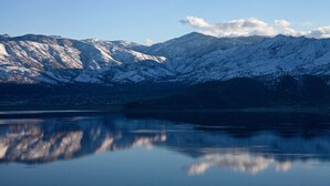 A mountain landscape with snow-covered peaks and a calm lake reflecting the scenery.