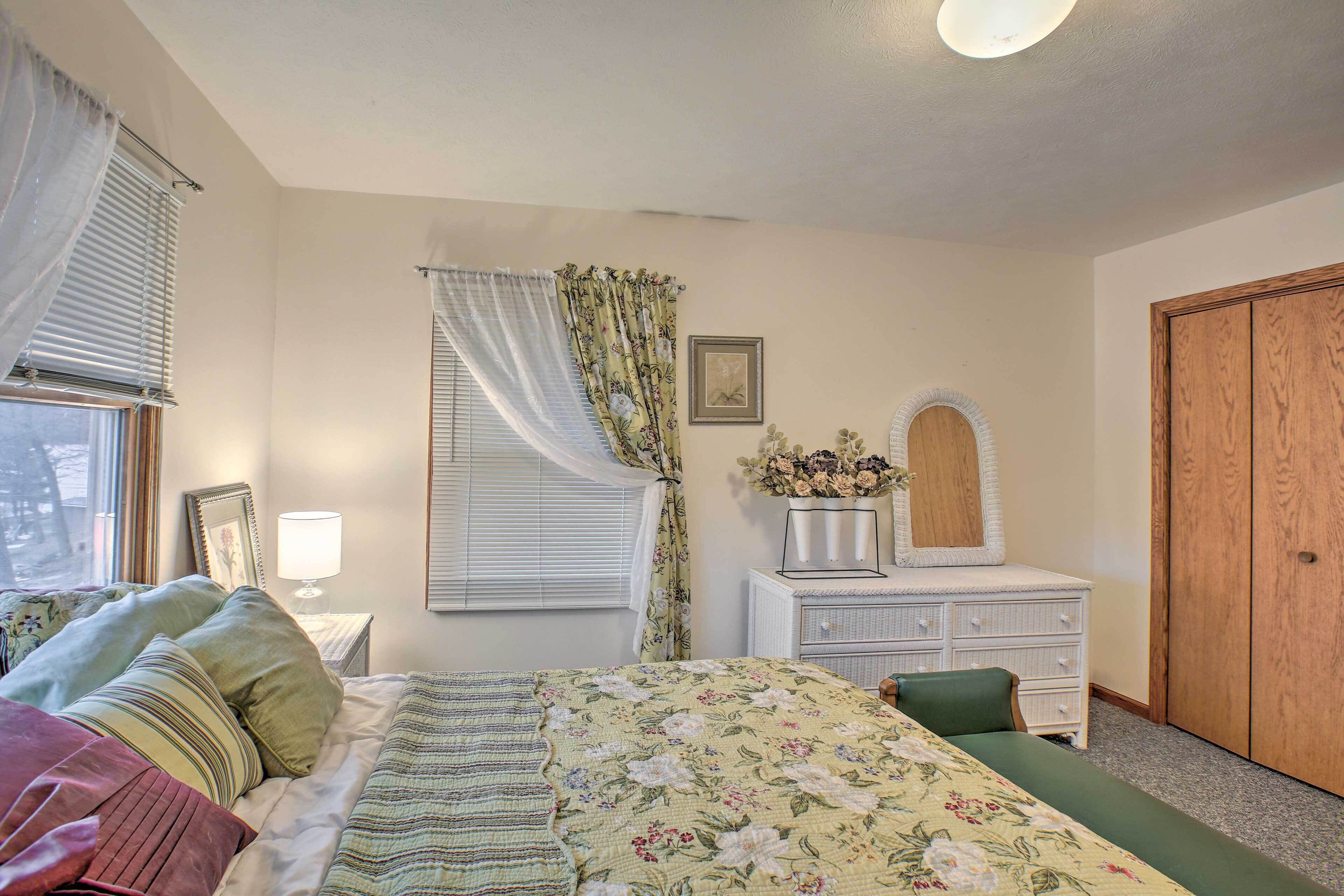 Une chambre à coucher avec un lit, une commode et une armoire en bois.