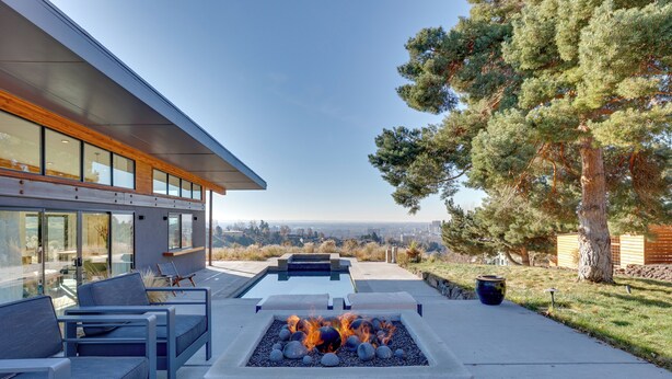 A modern outdoor patio with a fire feature, seating, and a view of the city. - Luxe, Modern Studio w/ Sweeping City Views! (Boise)