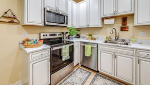 A modern kitchen with white cabinets, a stainless steel oven, a microwave, and a sink. - Charming Charlottesville Apt w/ Outdoor Space! (Charlottesville)