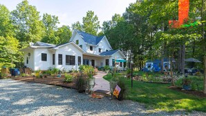 A two-story house with a gravel driveway and a garden area. - Charming Charlottesville Apt w/ Outdoor Space! (Charlottesville)