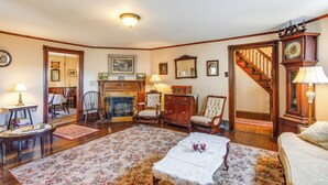A spacious living room with a fireplace, wooden furniture, and a staircase leading to another level. - Biking Trails, Fishing, Parks & More! Poconos Home (White Haven)