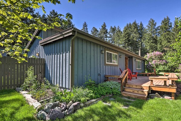 Une petite cabane avec une terrasse en bois et un porche abrité.