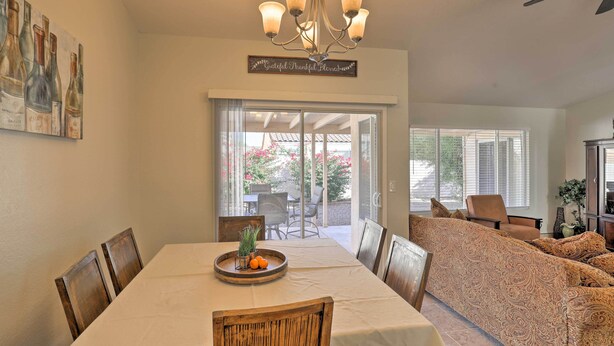 A dining area with a table set for four, a chandelier, and a view of the outdoors. - North Tucson Home w/ Patio by Catalina State Park! (Tucson)